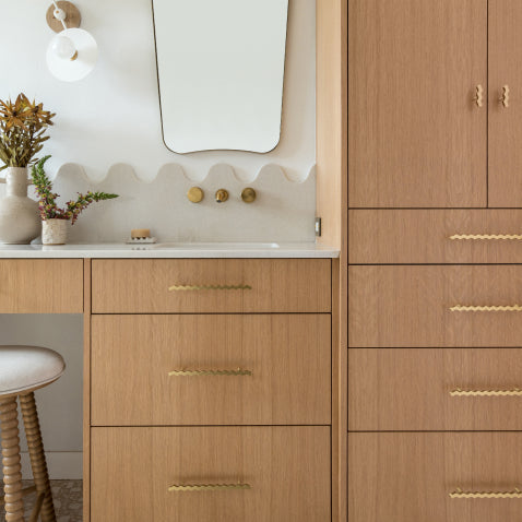 Oak bathroom vanity with brass squiggle hardware