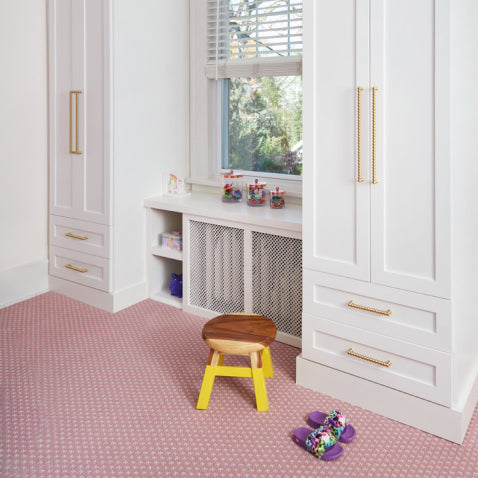 Childs nursery with white built-in storage and brass bobbin hardware
