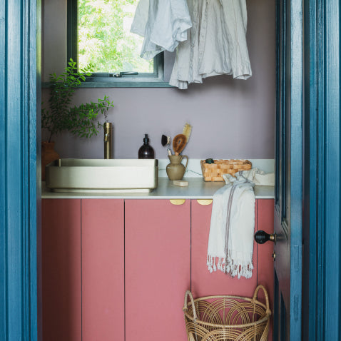Pink and blue utility room with brass edge pull handles